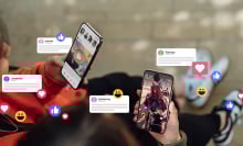 Closeup of two friends commenting and giving likes on social media platform via smartphone