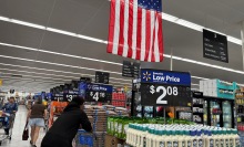 customers shop at a Walmart store with an american flag on ceiling