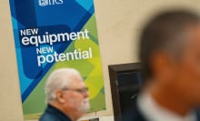 An IRS employee sits in front of a sign that reads "new equipment, new potential."