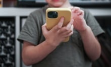 A child looks at a smartphone.