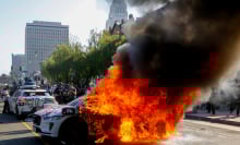 Waymo engulfed in flames on a downtown LA street.
