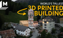 A drone shot captures the tall white Tor Alva at dusk, as lights have just gone out. It's surrounded by Mulegns' traditional houses, and the Alps are seen in the background