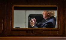 US President Donald Trump uses a cellphone aboard Marine One