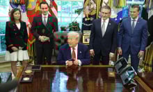 US President Donald Trump, center, holds an Apple Inc. iPhone