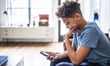 A child looks at their smartphone.