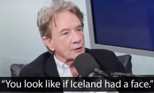 A man sits in a chair in front of a microphone. The quote at the bottom reads, "You look like if Iceland had a face."