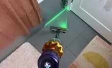 Dyson V12 Detect Slim cleaning bathroom floor with green laser