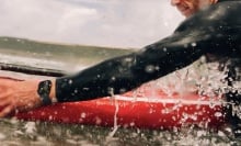 person wearing apple watch on surfboard