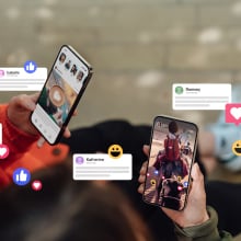 Closeup of two friends commenting and giving likes on social media platform via smartphone