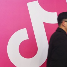 A man walks by a TikTok logo.