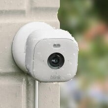 the blink mini 2 security camera attached to the side of a house, getting wet in the rain