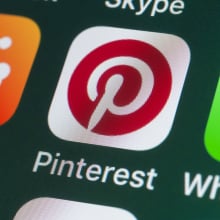 The buttons of the app Pinterest, surrounded by Reddit, Whatsapp, Skype and other apps on the screen of an iPhone.
