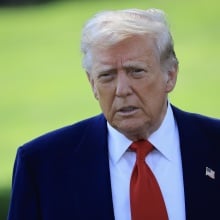President Donald Trump on a green lawn.