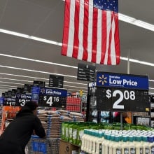customers shop at a Walmart store with an american flag on ceiling