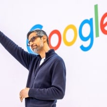 Sundar Pichai acknowledges the crowd in front of a Google logo