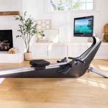the hydrow pro rowing machine in a bright living room in front of a fireplace