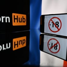  screens displaying an under-18 logo, the logo of the pornographic site Pornhub and a French flag