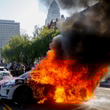 Waymo engulfed in flames on a downtown LA street.