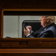 US President Donald Trump uses a cellphone aboard Marine One