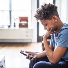 A child looks at their smartphone.