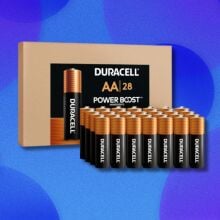 Duracell batteries sit in rows in front of a brown Duracell box. Behind this is a blue background with blue circles