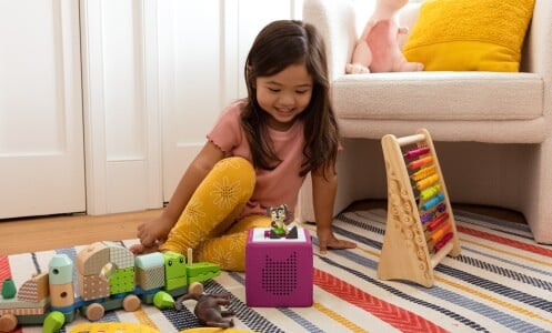 girl sitting on floor near toys