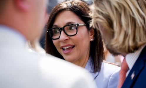 A close shot of Yaccarino talking to a group of people in the White House Rose Garden.