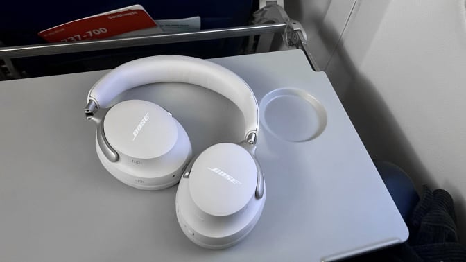 the bose quietcomfort ultra headphones on airplane tray table