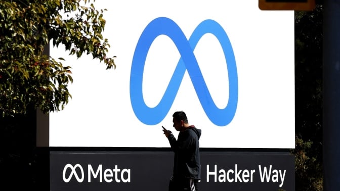 A man walks by Meta headquarters in Menlo Park, California.