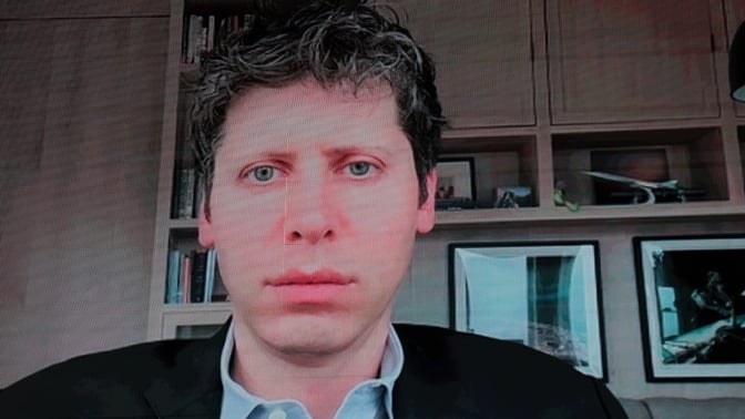 OpenAI CEO Sam Altman speaks remotely on a screen