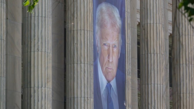 a banner of president trump looms large on the columns of the U.S. agriculture building in Washington, D.C.
