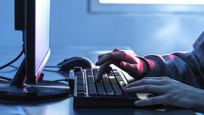 hands on a keyboard at a desktop computer