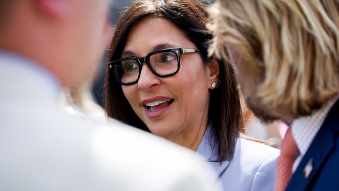 A close shot of Yaccarino talking to a group of people in the White House Rose Garden.