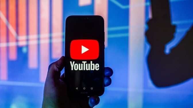 A YouTube logo is displayed on a smartphone with bar graph in the background.