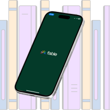 A bookshelf behind a smartphone showing the Fable logo.
