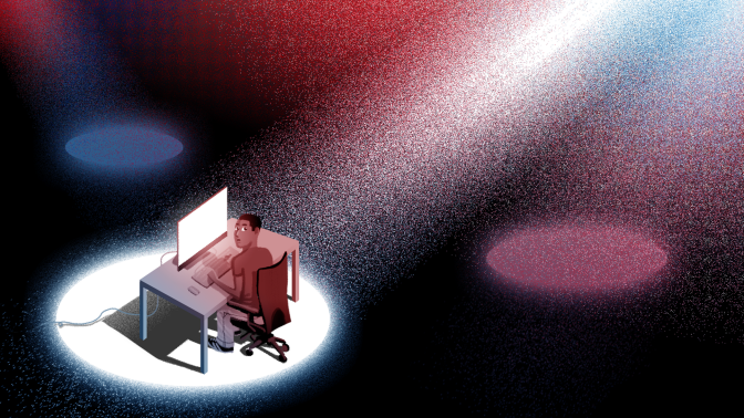 a person sitting at a desk illuminated by a big spotlight
