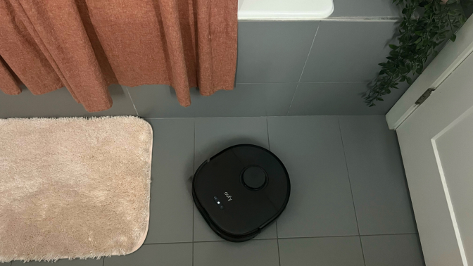 Eufy X10 Pro Omni robot vacuum mopping gray tile floor by bathtub